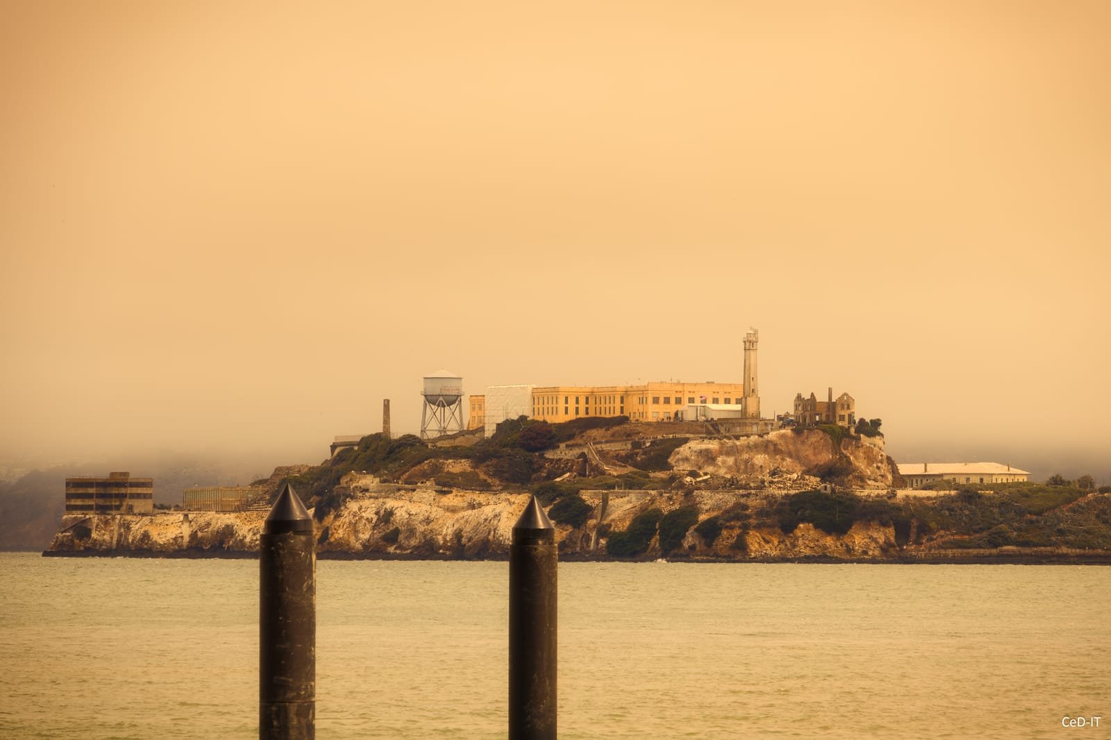 Île coiffée de bâtiments dans une lumière orangée