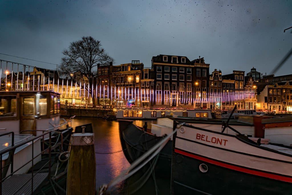 Quais illuminés et bateaux à la tombée de la nuit
