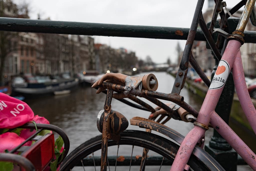 Vélo appuyé contre la rambarde d'un pont au-dessus d'un canal